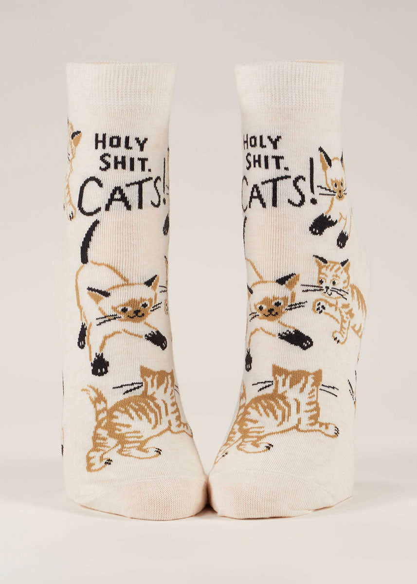 White ankle socks for women that say "Holy Shit. Cats!" on them and show different kinds of cats in shades of brown and black. 