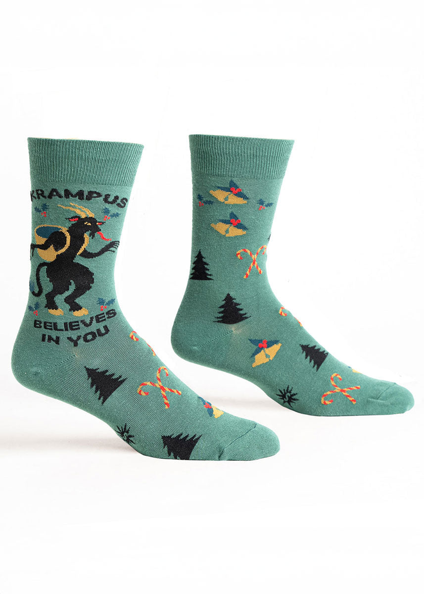 Green men's crew socks with Krampus Christmas-themed designs on a white background.