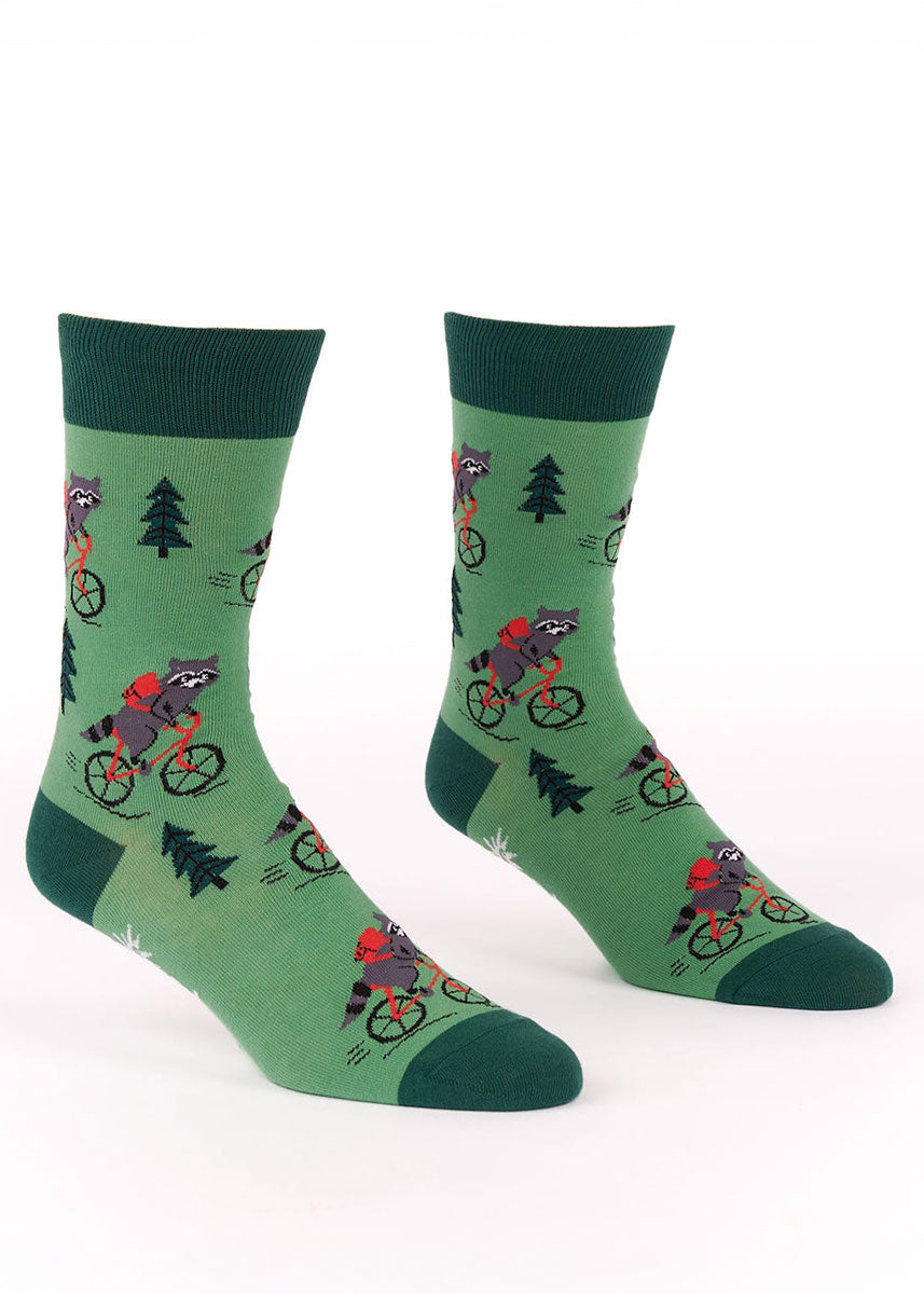 Green men's crew socks with a design of a raccoon riding a bike.