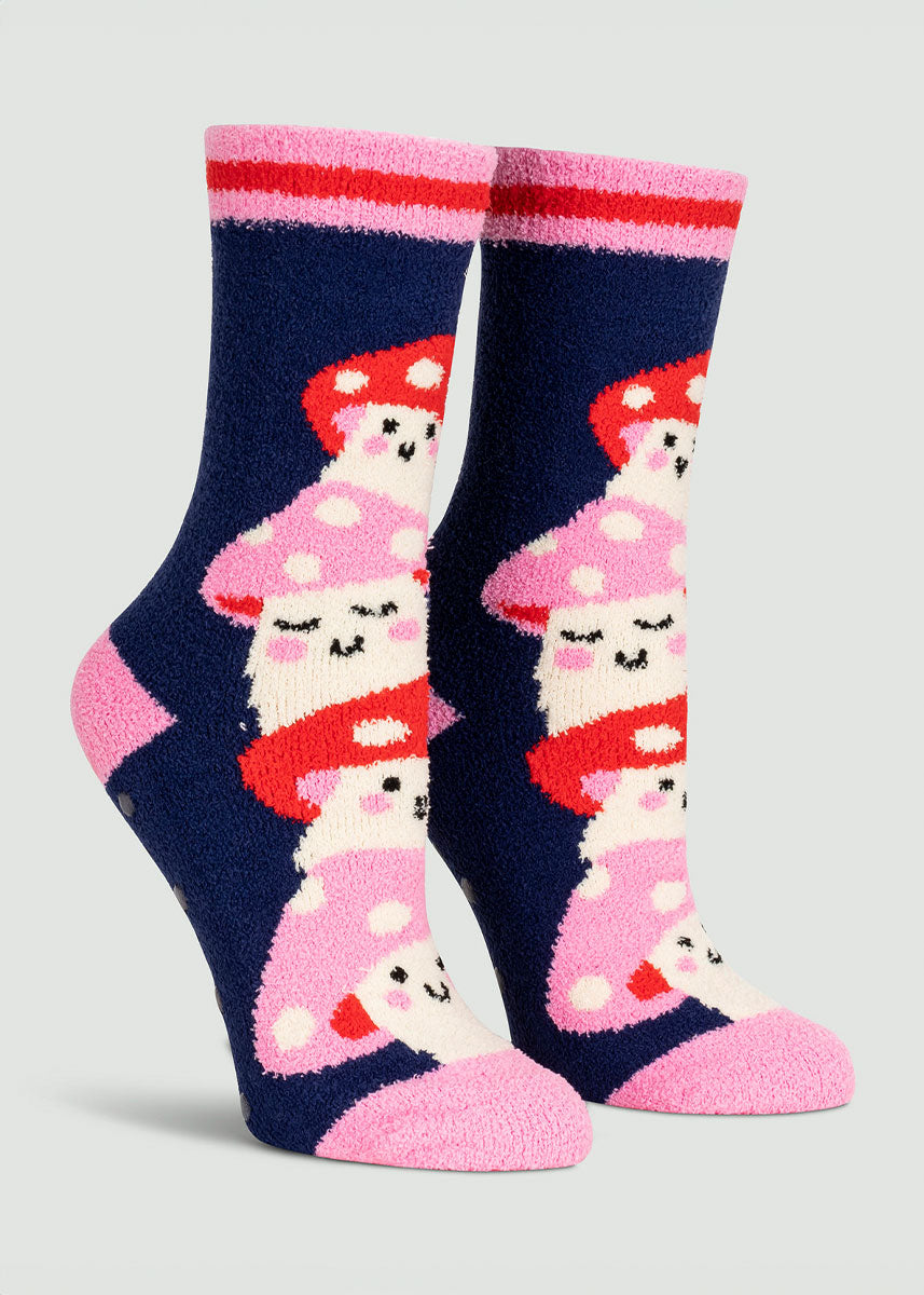 Navy fuzzy slipper socks for women with a pink and red striped cuff featuring pink and red cartoon mushrooms with smiling faces stacked on top of each other.
