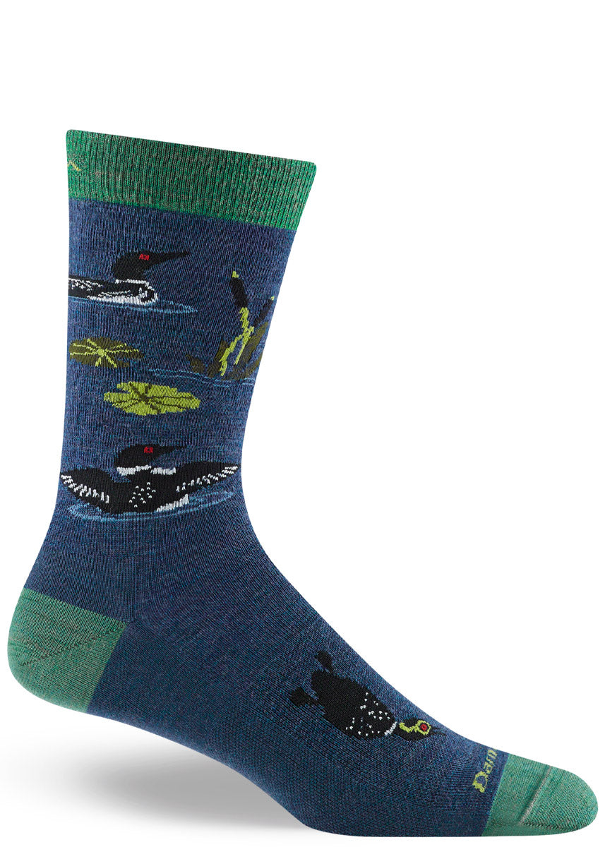 Dark blue wool crew socks for men that feature several black and white loons in a lake surrounded by lilypads and cattails.