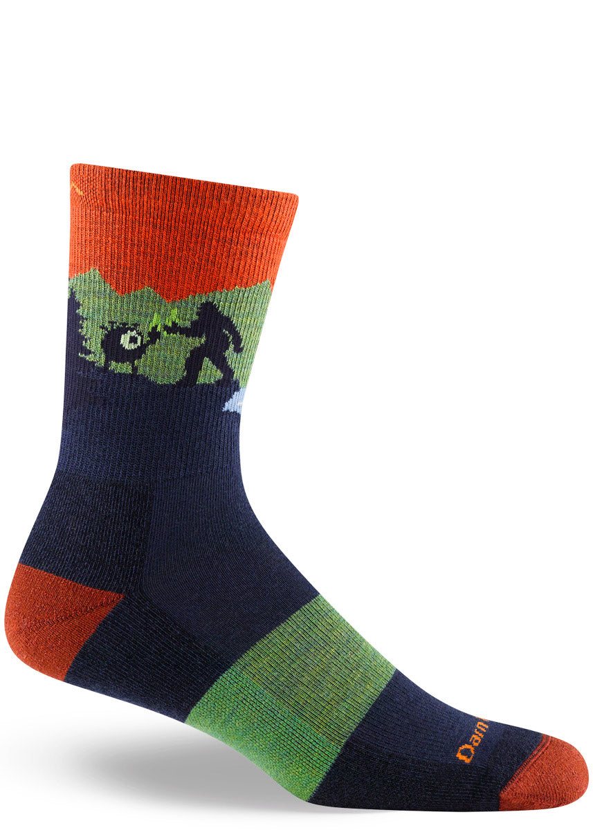 Men's crew hiking socks depict Sasquatch and an alien drinking beer while the Loch Ness Monster looks on, in shades of orange, navy and green.