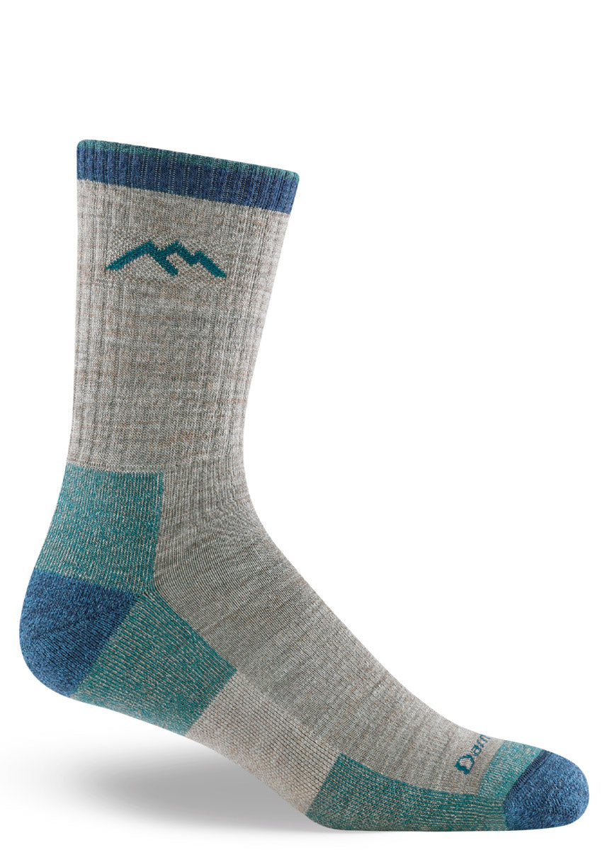 Gray hiking socks for men in crew length with a dark blue cuff, heel, and toe.