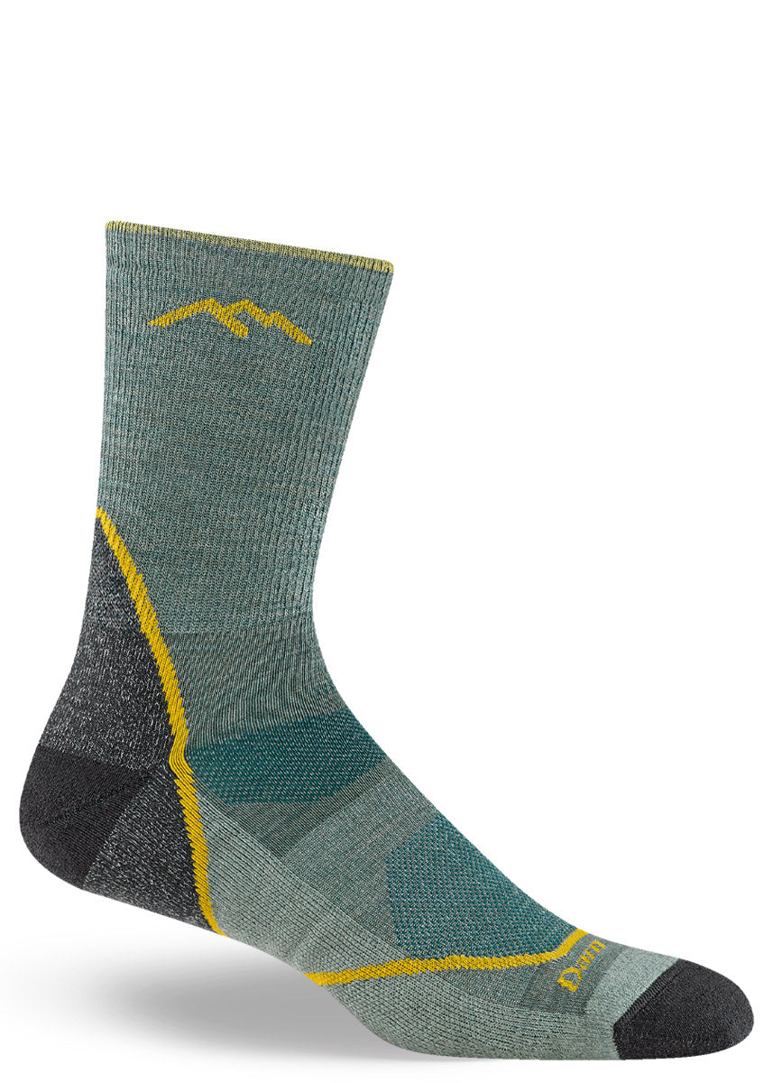 Teal green wool men's crew sock with golden yellow accents on a white background.