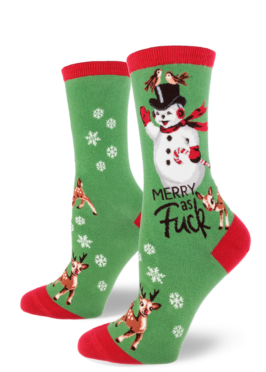 Green holiday novelty socks for women with a red cuff, heel, and toe that say &quot;Merry as Fuck&quot; and feature a retro-style snowman, two reindeer, and snowflakes.