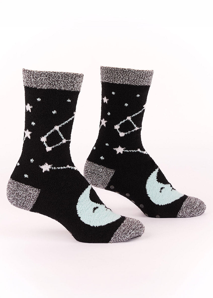 Black fuzzy socks with celestial designs including a moon and constellations.
