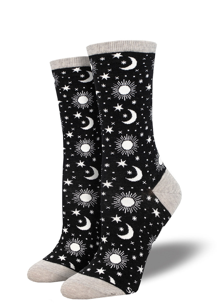 Black crew socks for women with an allover pattern of white suns, moons and stars, accented with heather gray at the heel, toe and cuff.