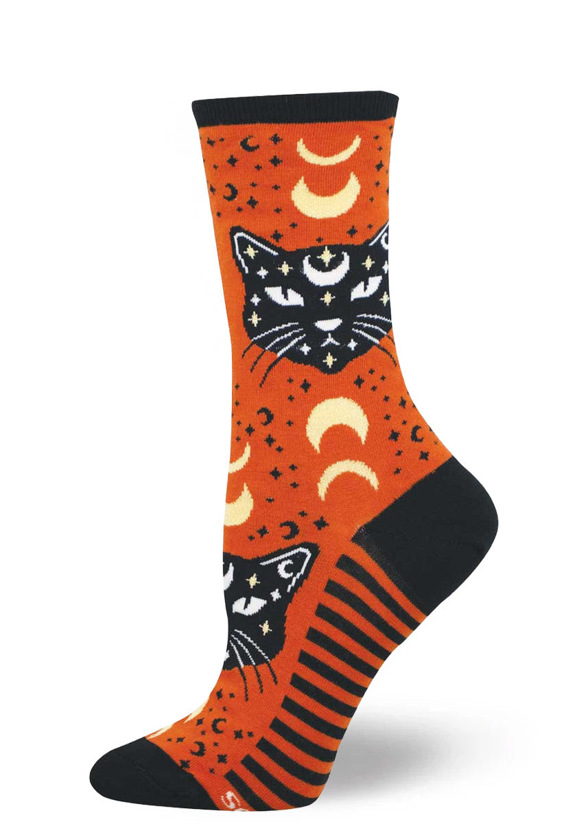 Orange socks with black cat and moon design on a white background.