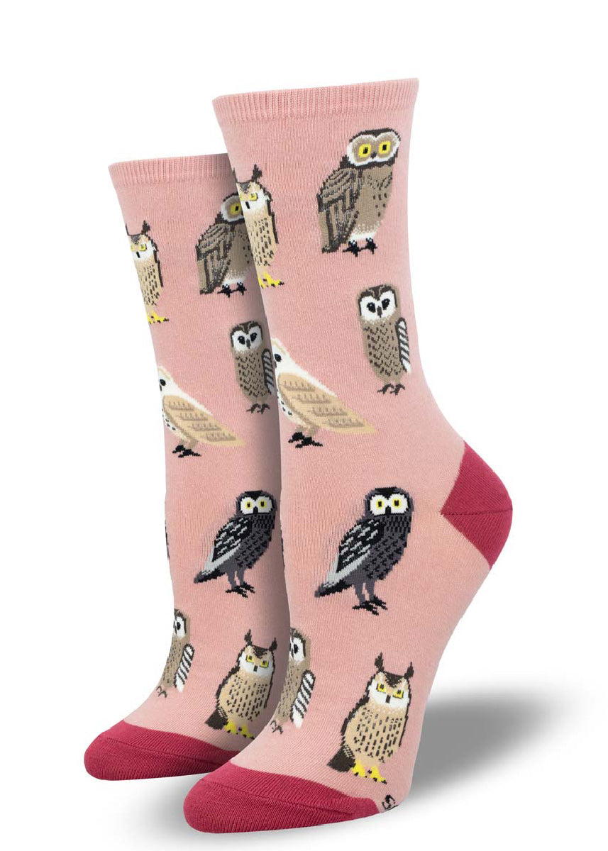 Pink crew socks for women with an allover pattern of various kinds of owls in shades of brown, tan, and white. 