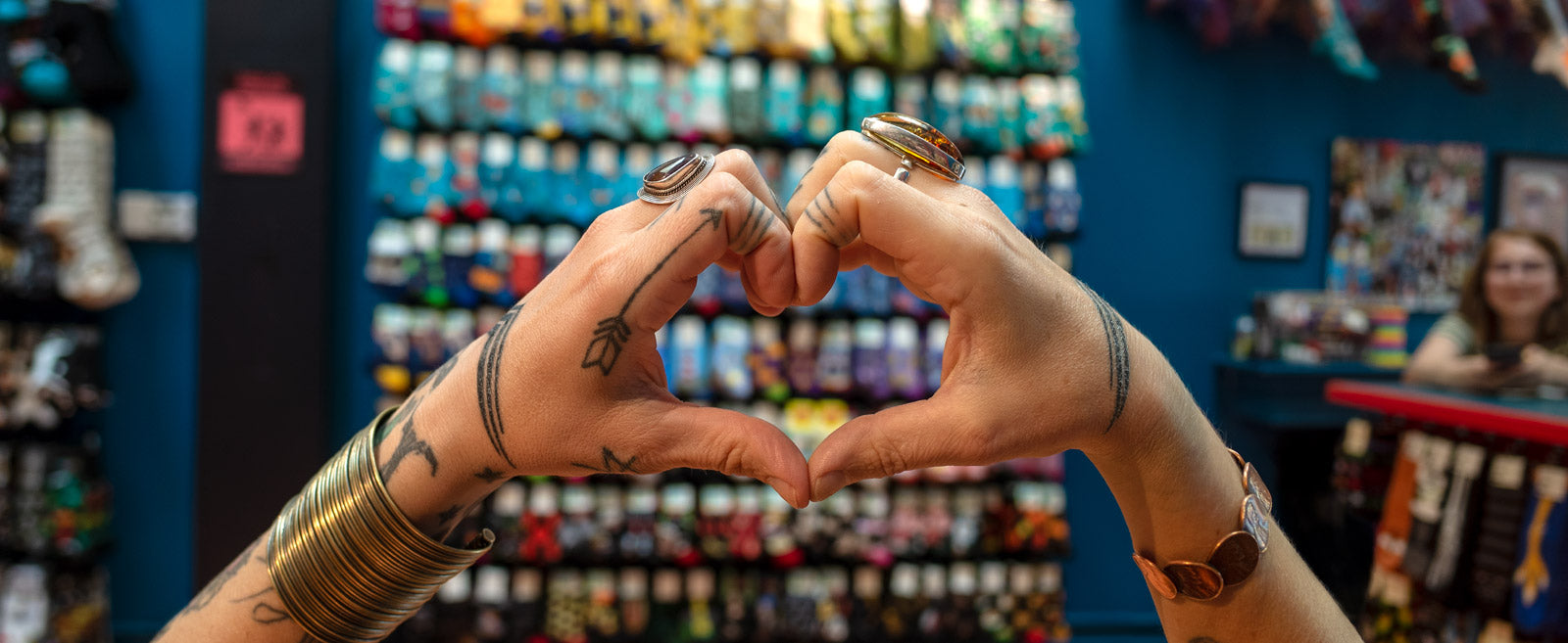 An employee makes a heart shape with her hands at Cute But Crazy Socks, a sock store in Bellingham, Washington.