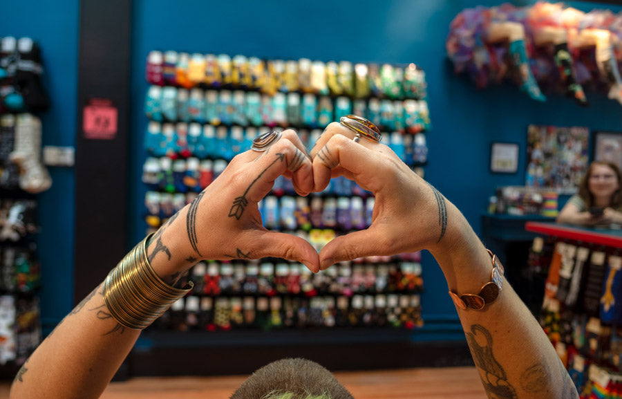 An employee makes a heart shape with her hands at Cute But Crazy Socks, a sock store in Bellingham, Washington.
