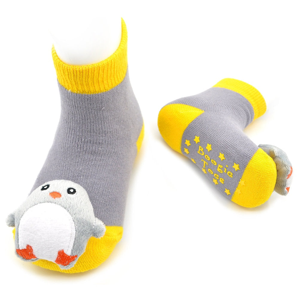 A pair of gray ankle socks for babies with bright yellow cuffs, toes, and heels, featuring a plush penguin on one sock and the brand name 'Boogie Toys' printed on the sole.