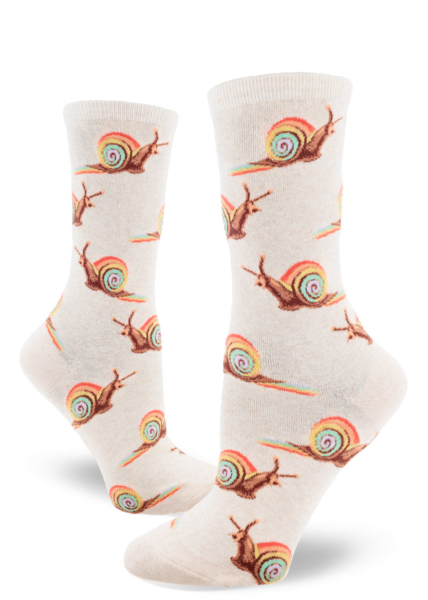 Cream crew socks for women with an allover pattern of brown snails with pastel rainbow shells leaving a rainbow slime trail behind them.