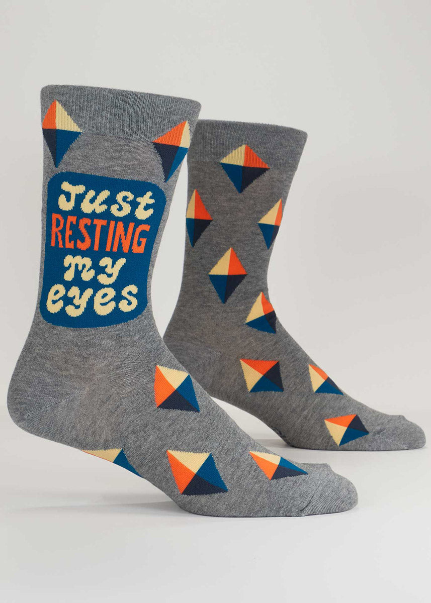 Gray crew socks for men with an orange, blue, and cream geometric pattern and the words "Just resting my eyes."