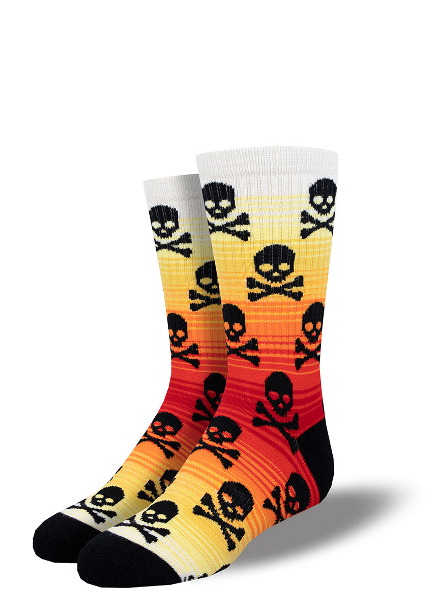 Ribbed athletic socks for kids with a black skull and crossbones design on an orange, red and yellow gradient.