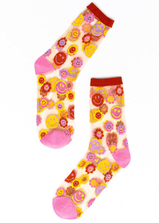 Sheer crew socks for women with an allover pattern of smiley face daisies in a color palette of yellow, lavender, pink, and orange.