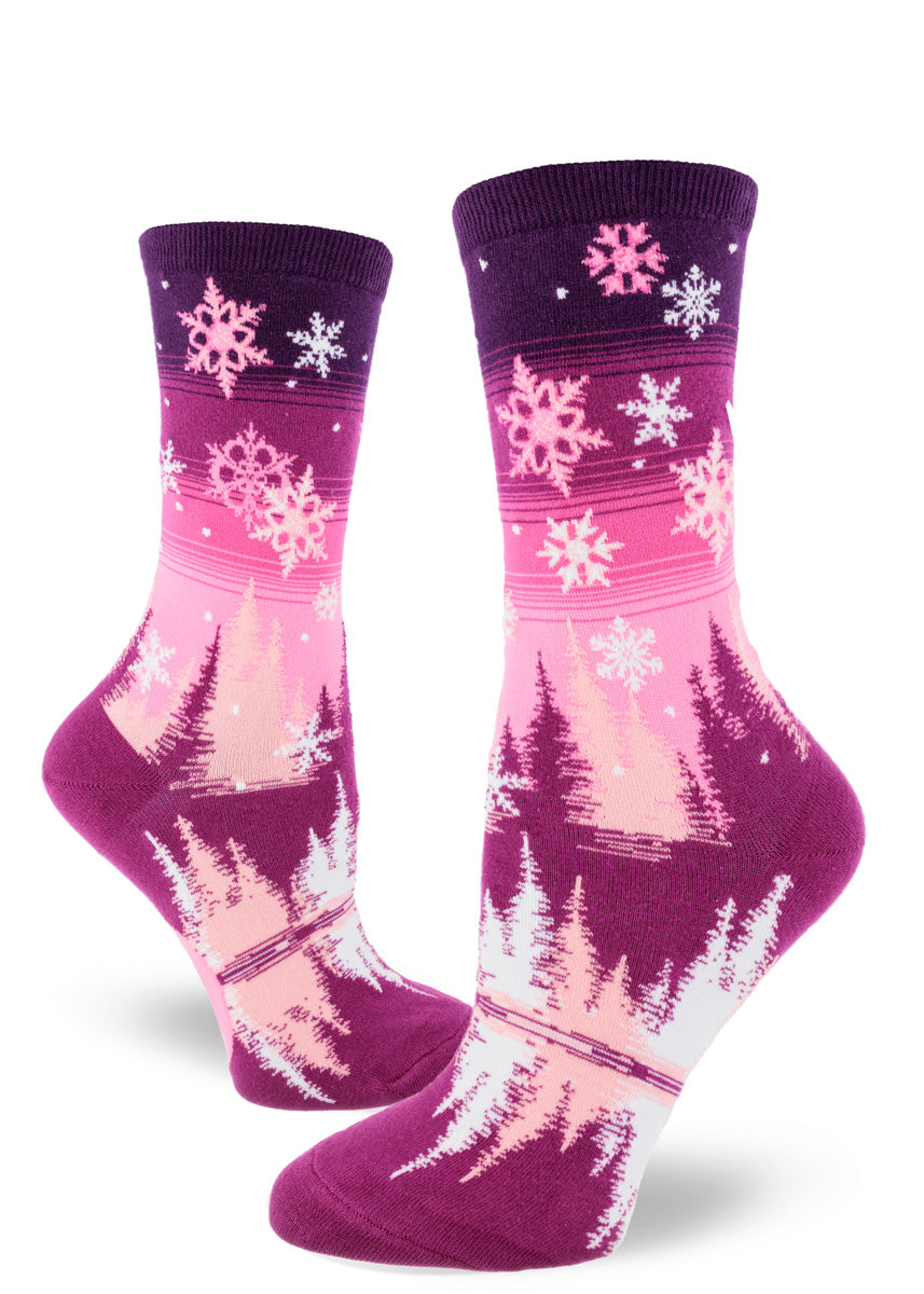 Pink snowflake crew socks for women with a landscape of a snowy night sky and pink fir trees.