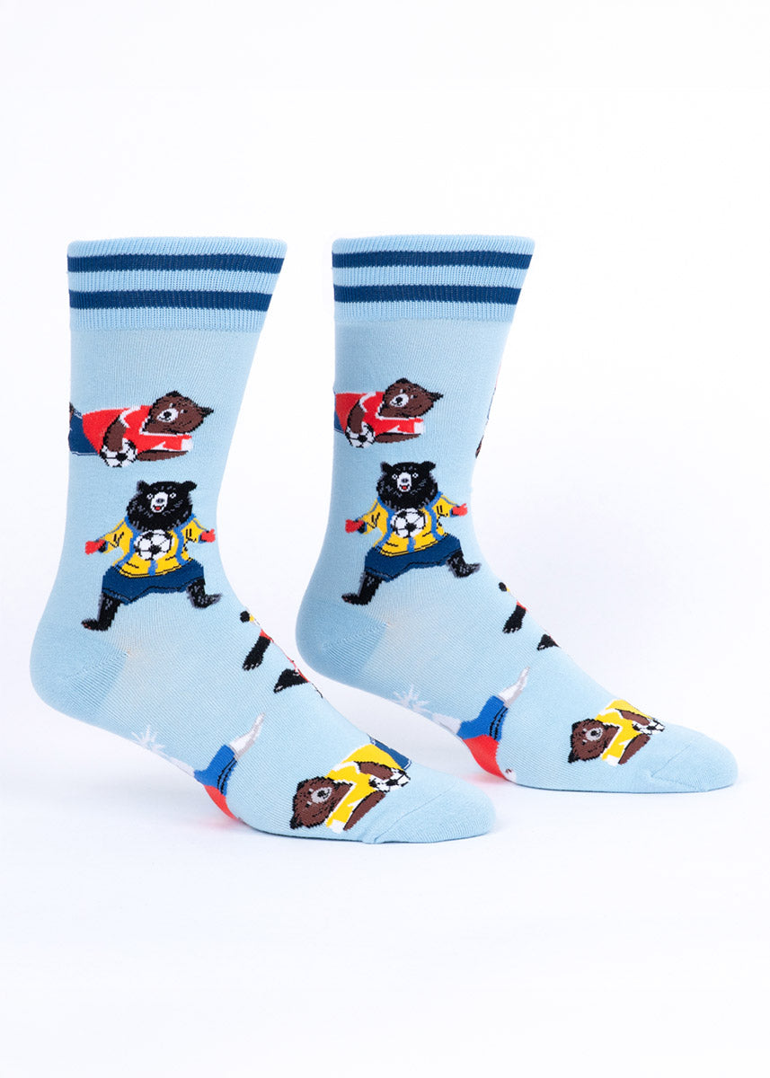 Light blue men's crew socks with soccer-playing bear illustrations on a white background.