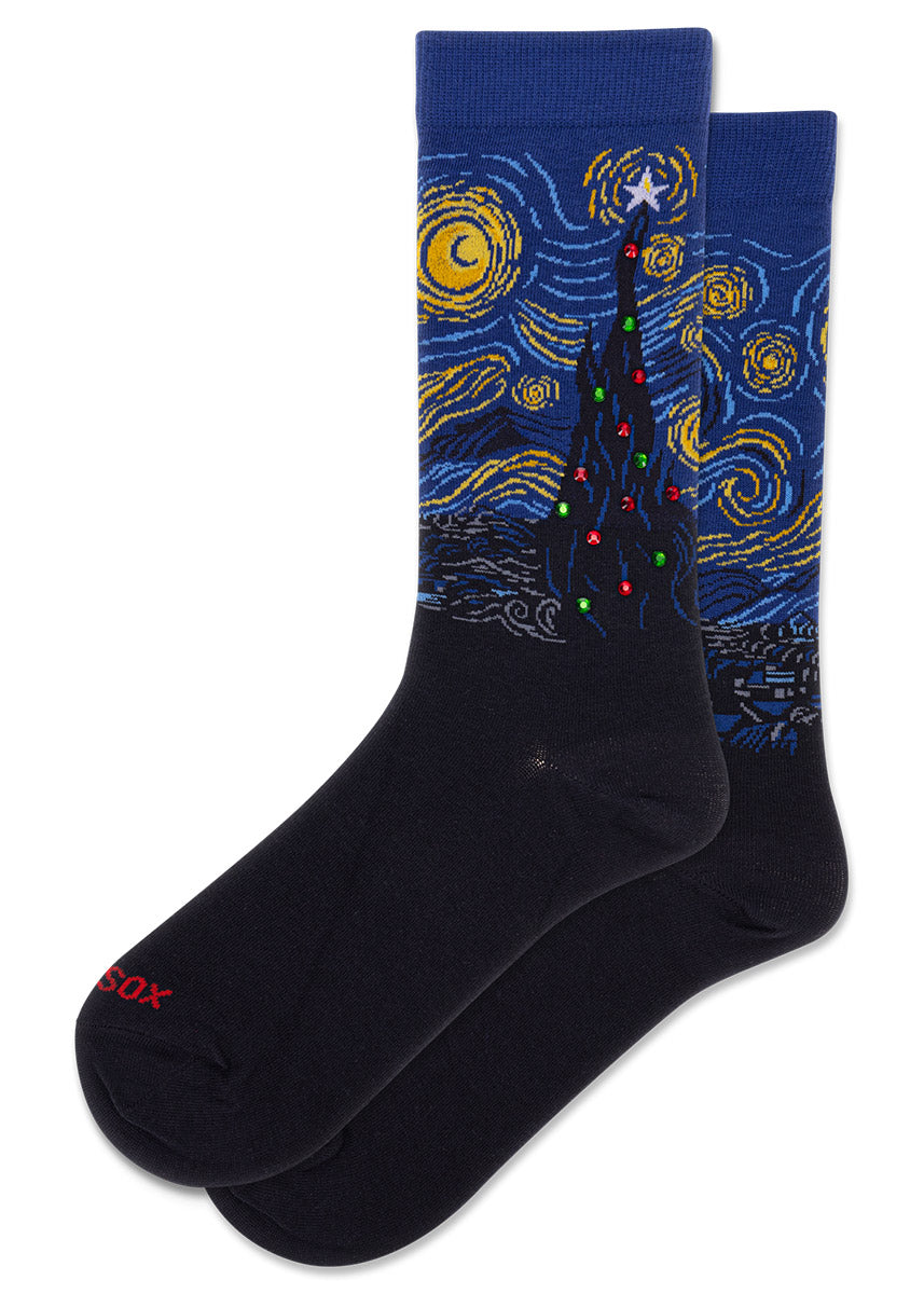 Blue and black crew socks for women feature a rendering of van Gogh's Starry Night painting, with red and green rhinestone Christmas ornaments on the iconic painted tree. 