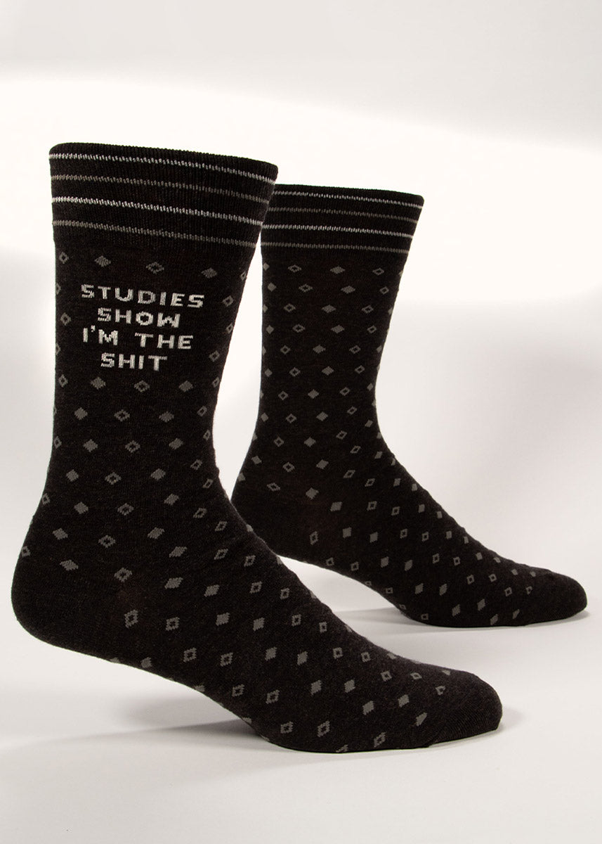 Charcoal gray men's dress socks with a subtle diamond pattern and “Studies Show I'm the Shit” knit into the leg. 