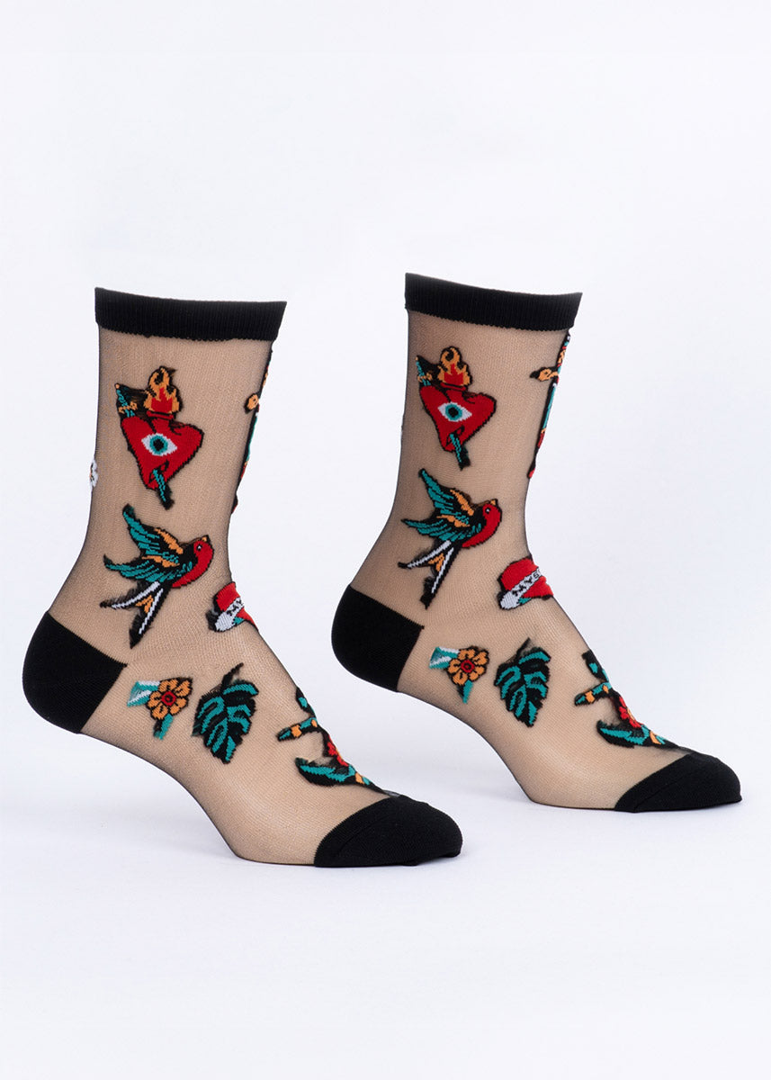 Sheer black socks with colorful vintage tattoo-style designs on a white background.