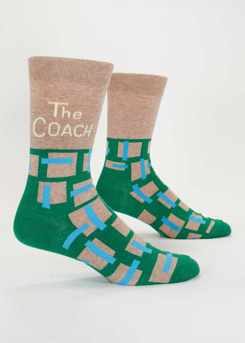 Green and brown men's crew socks with 'The Coach' text on the leg and a geometric pattern on the foot.