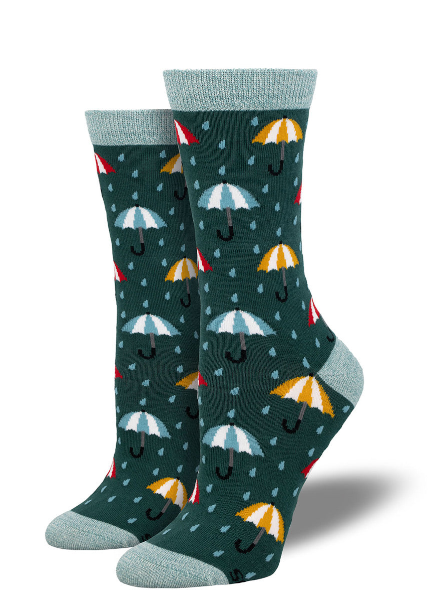 Dark teal crew socks for women that feature a repeating pattern of colorful umbrellas and blue raindrops.