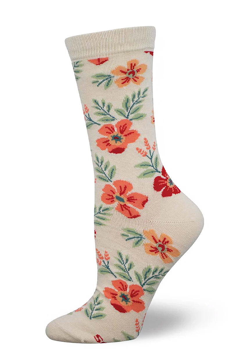Cream crew socks for women with an allover pattern of wildflowers in shades of pink, red, and orange and light green foliage.