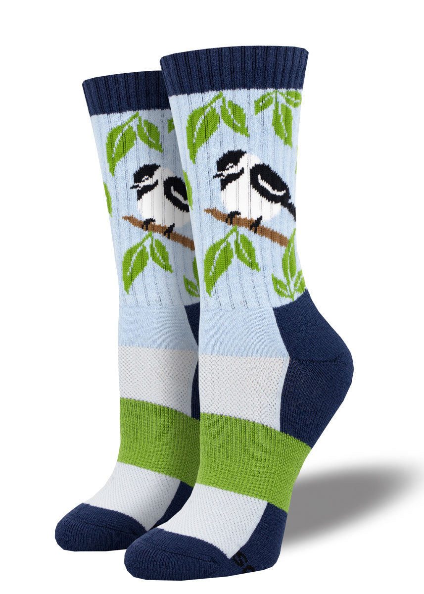 Light blue, navy and green wool hiking socks featuring a black and white chickadee sitting in a tree.