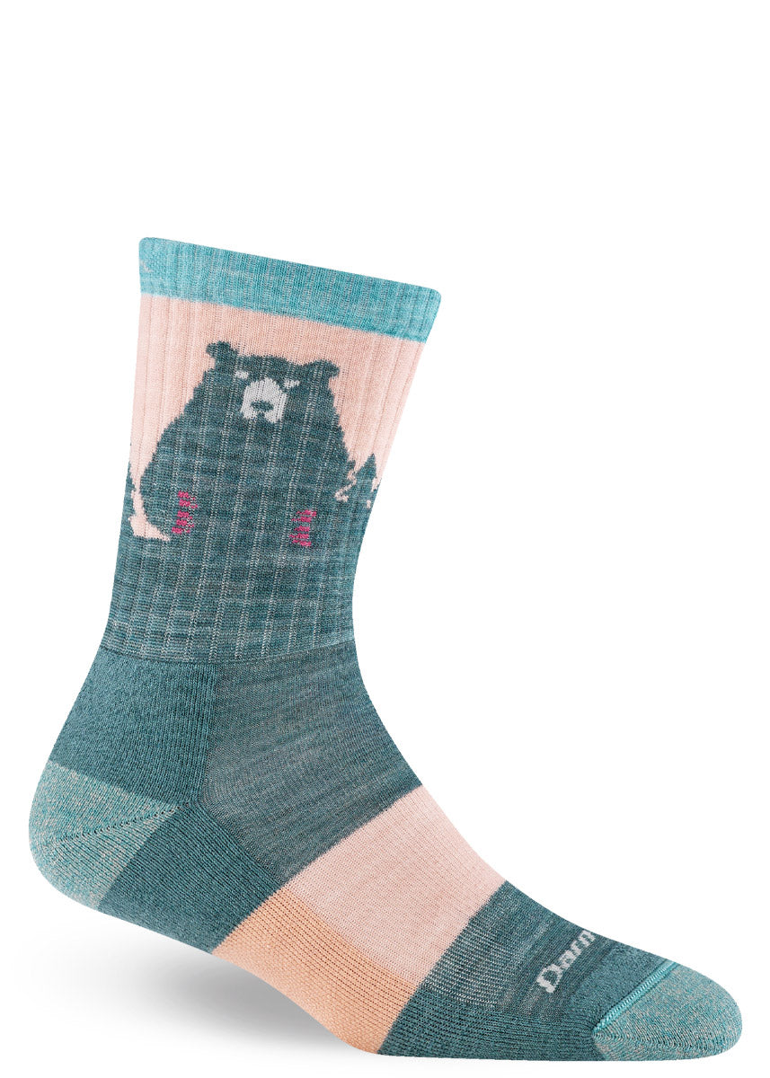 Teal and pale pink wool hiking socks for women featuring a bear design against a forest background.