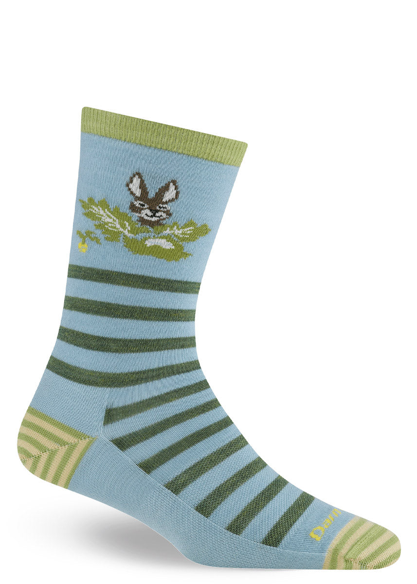 Light blue sock with green striped pattern and garden-themed rabbit design on a white background.