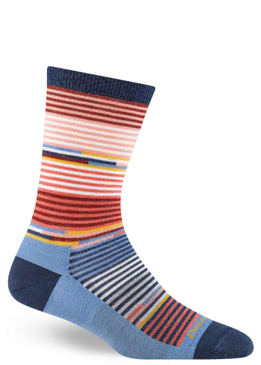 Merino wool crew socks for women with an allover pattern of thin stripes in shades of blue, pink, and rust. 