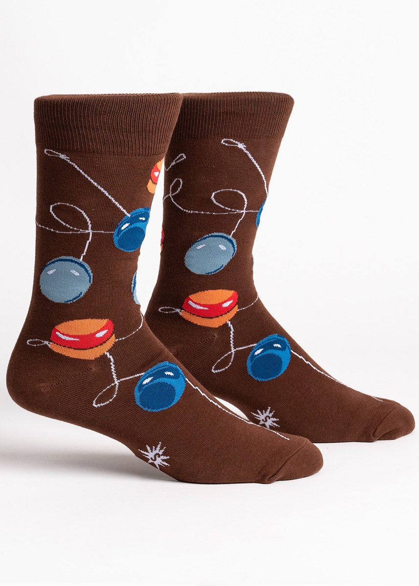 Brown crew socks for men with an allover pattern of yo-yos in shades of blue, orange, and gray.