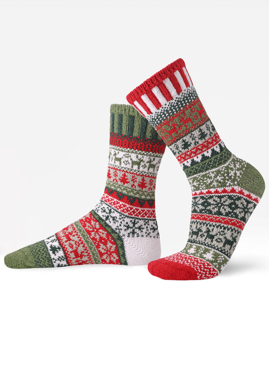 Intentionally mismatched holiday crew socks with different sections featuring various geometric patterns like reindeer and snowflakes in shades of red, green, and white.