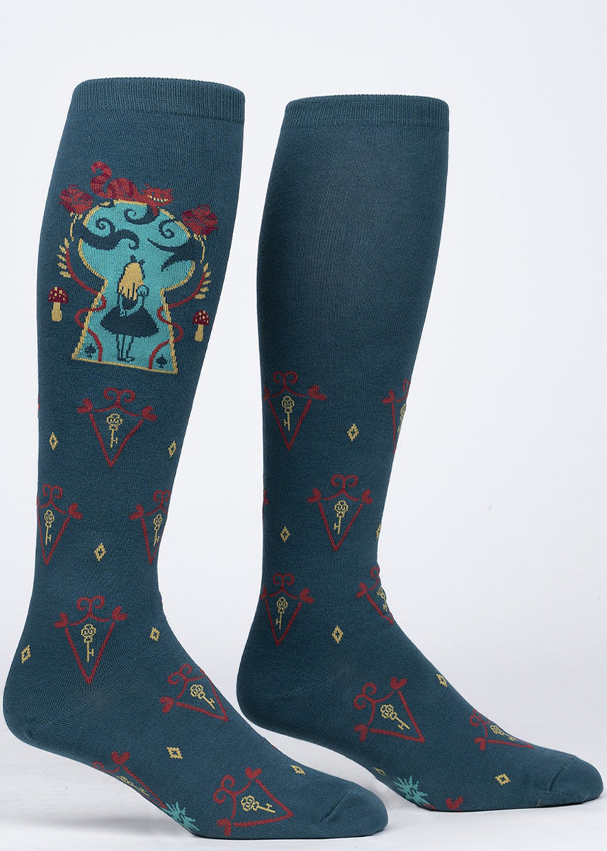 Extra-stretchy knee high socks feature an illustration of Alice in Wonderland inside a magic keyhole with the Cheshire cat resting on top and a repeated key design.