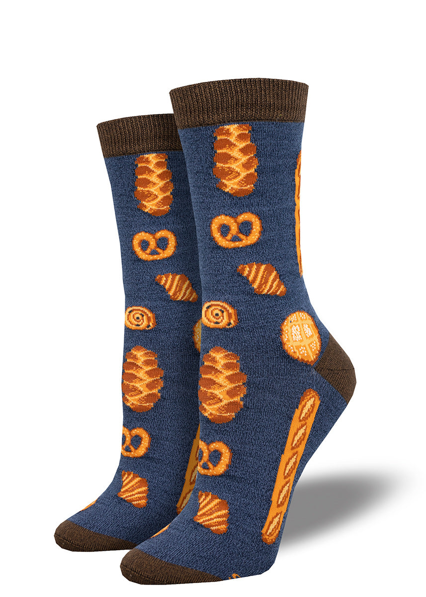 Navy women&#39;s crew socks with brown accents feature a pattern of various types of bread including baguettes, challah bread and pretzels.