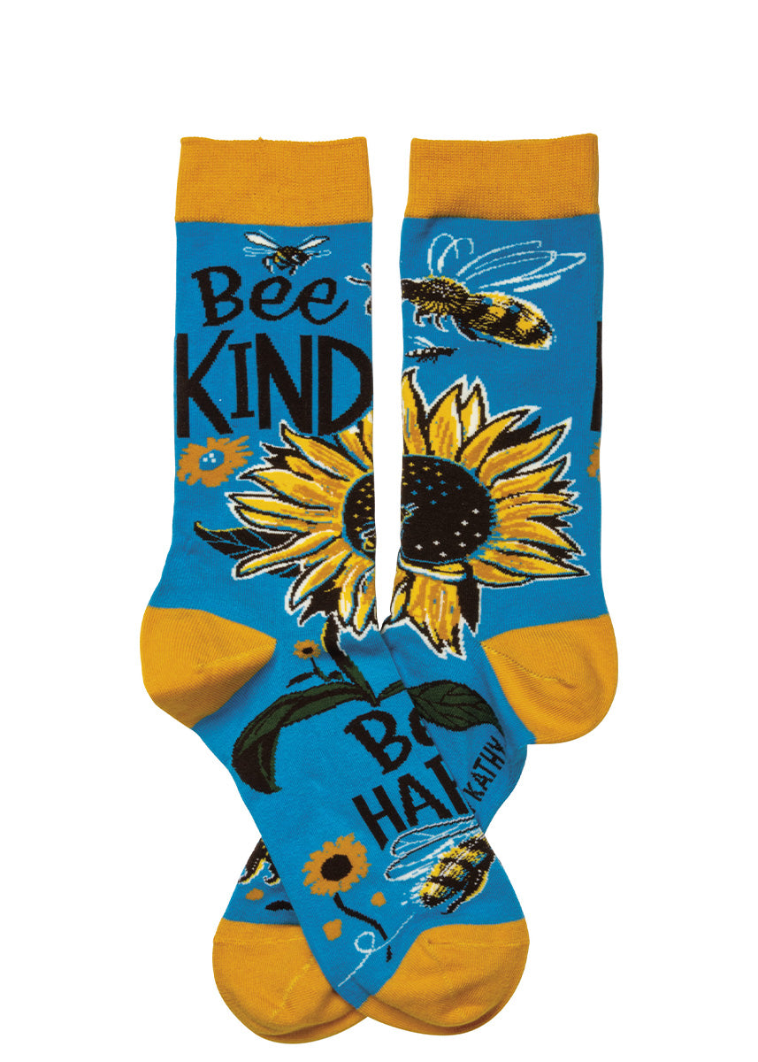 Cute socks for women show bees pollinating yellow sunflowers with the words, "Bee kind, Bee happy."