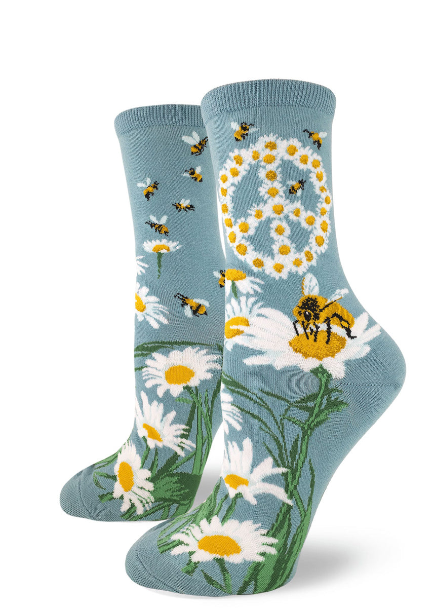 Bee socks for women with honeybees and daisy flowers forming a peace sign on a light blue background
