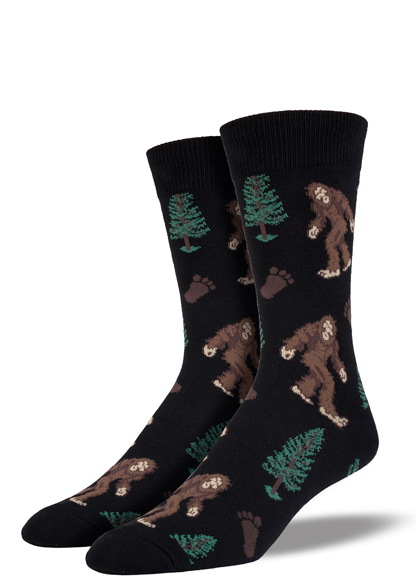 Bigfoot men&#39;s socks with Sasquatch and trees plus Bigfoot footprints on a black background