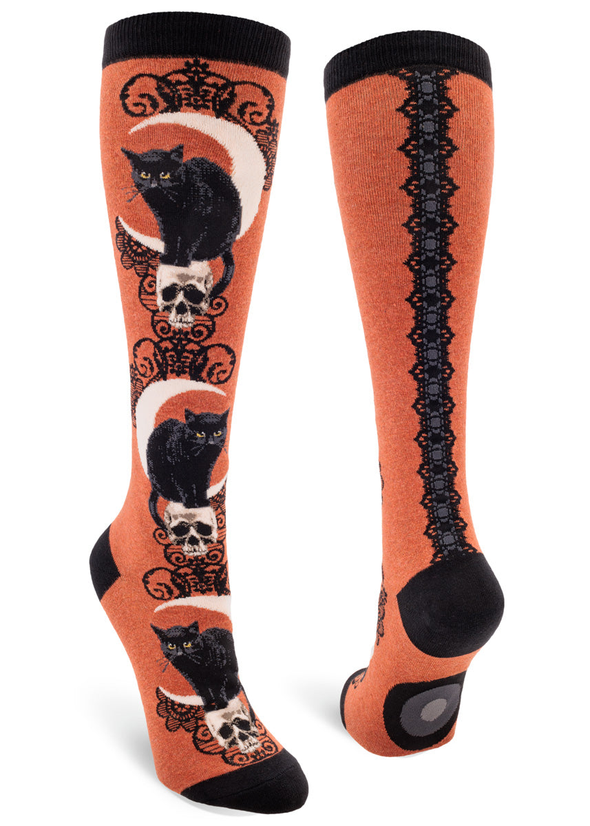 Heather sienna knee socks with a design of black cats, crescent moons and skulls accented with a black lace pattern.
