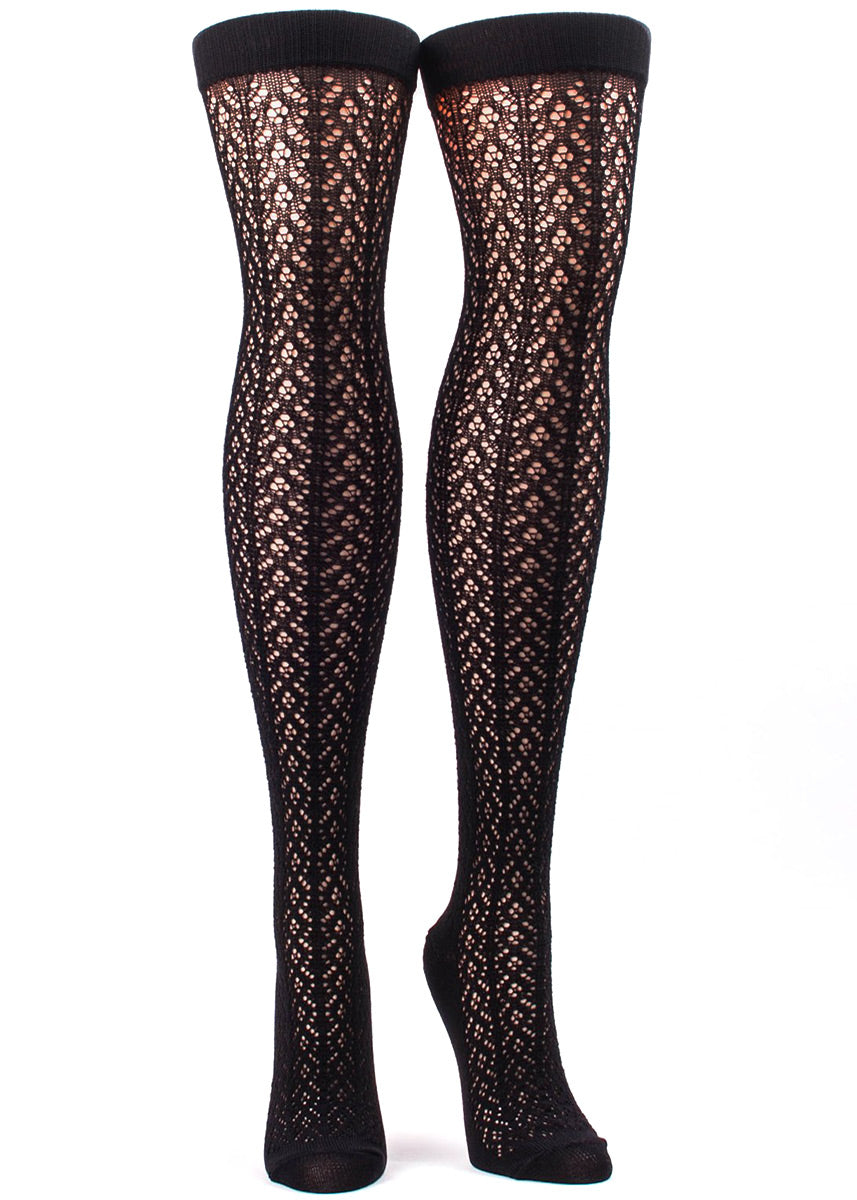 Over-the-knee socks for women feature a delicate crochet pattern in black.