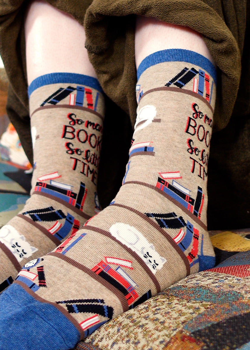 Reading socks for women show bookshelves full of books with the words, &quot;So many books, so little time.&quot;