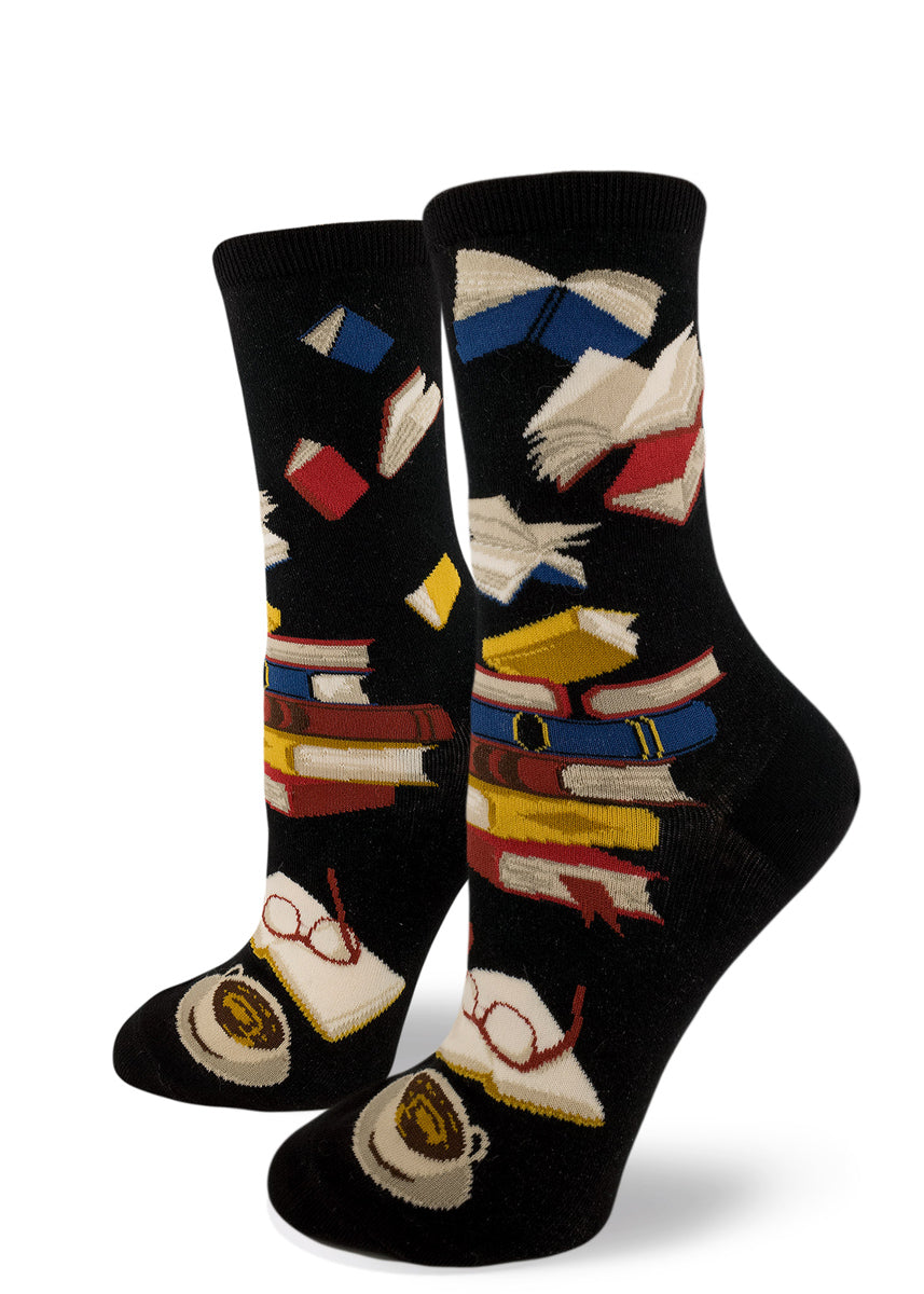 Book socks for women with stacks of books and flying books in the air on a black background