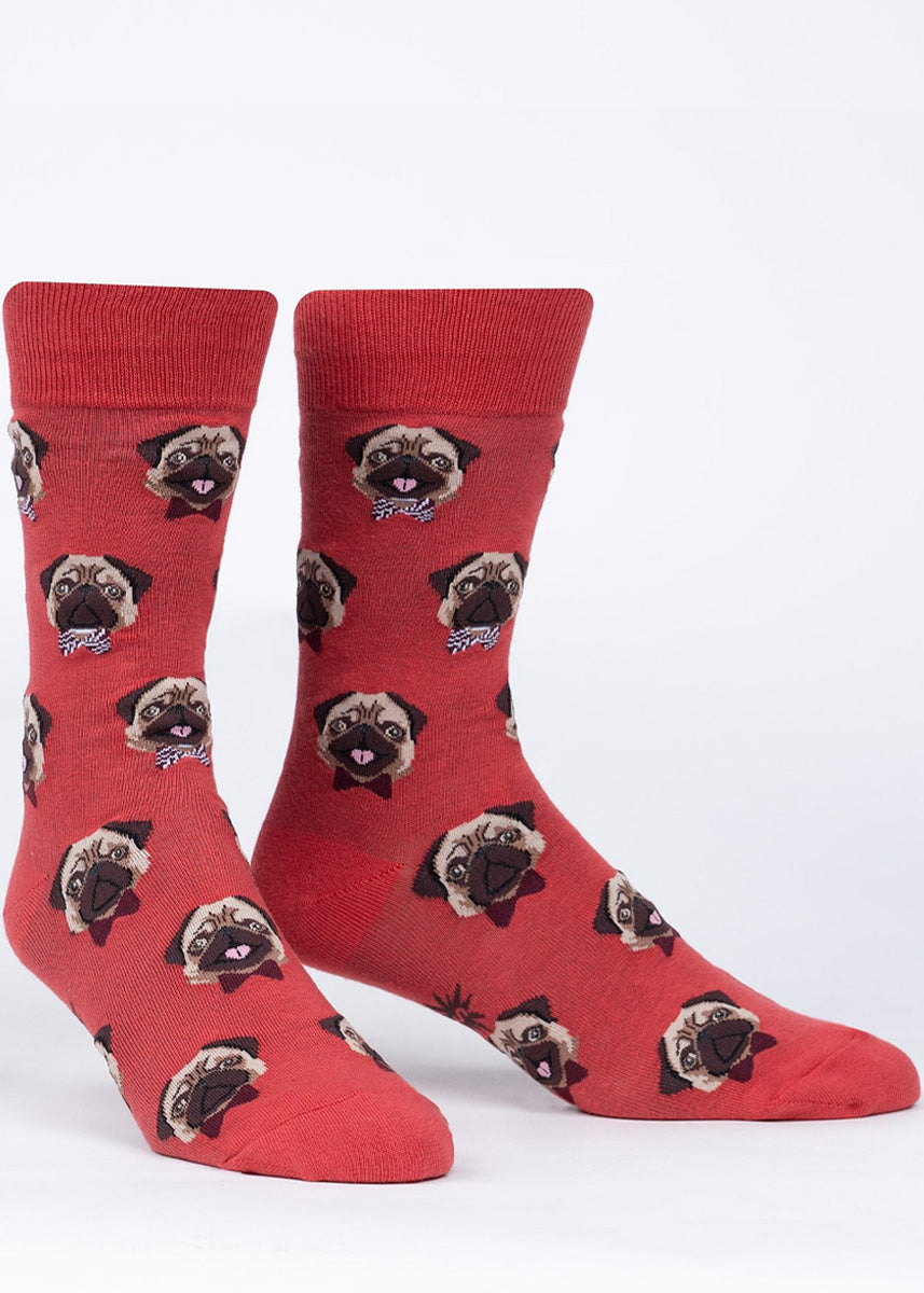 Dog socks for men feature adorable pug faces with little bowties on a red background.