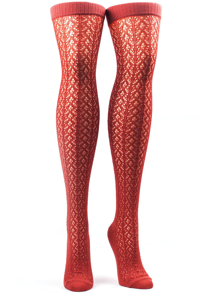 Over-the-knee socks for women feature an open crochet pattern in beautiful burnt orange. 