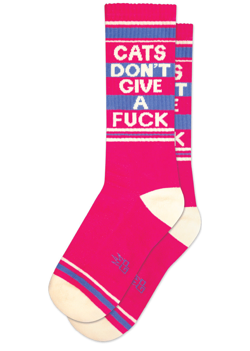 Hot pink retro gym socks with white and purple stripes and the phrase “CATS DON&#39;T GIVE A FUCK&quot; on the leg.