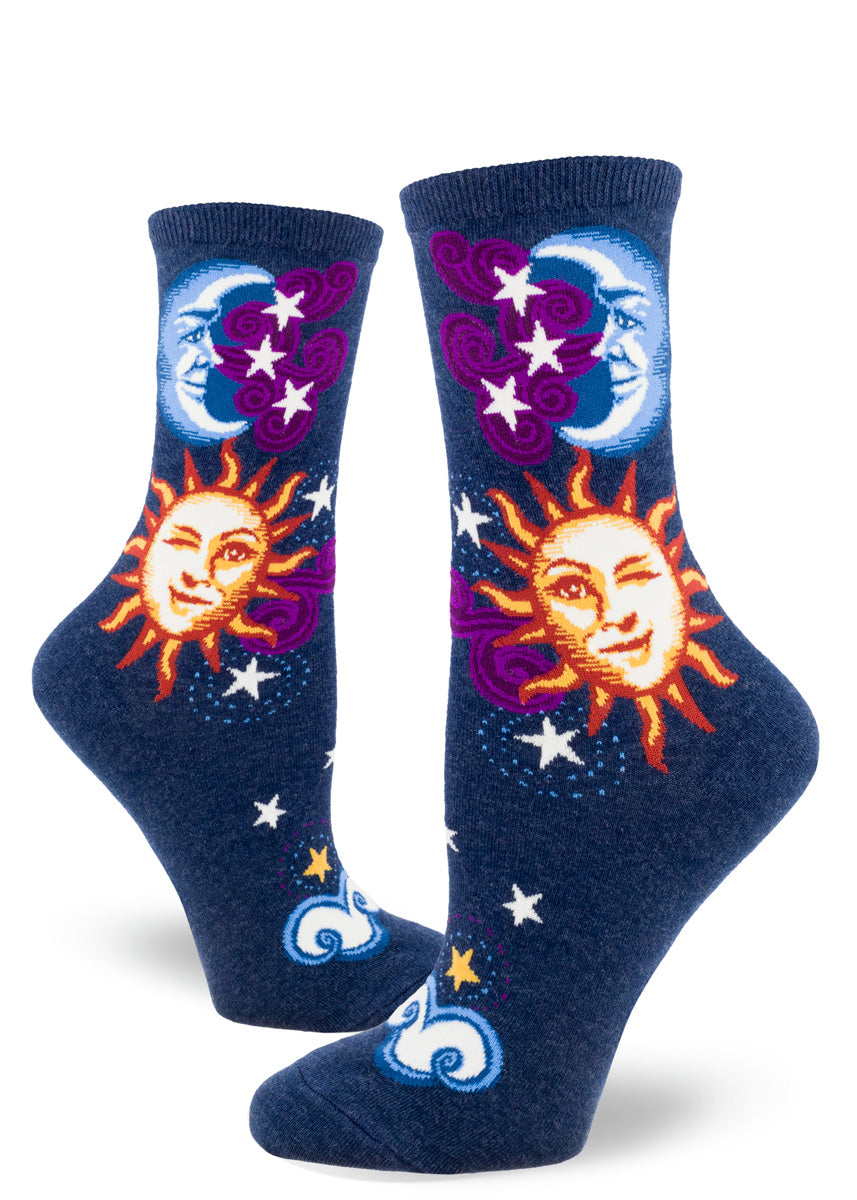 A blue moon grins and a yellow sun winks next to purple clouds of stars on these celestial crew socks for women.