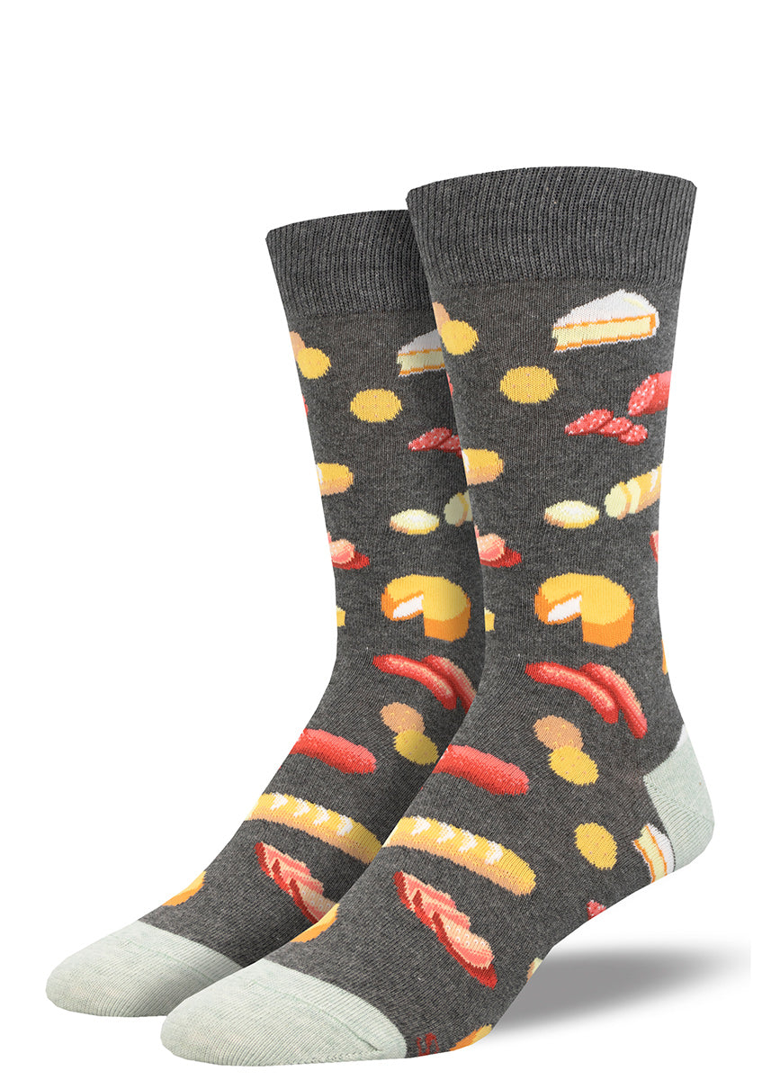 Heather gray men's crew socks with a charcuterie theme feature an assortment of meats, cheeses and sliced baguette.