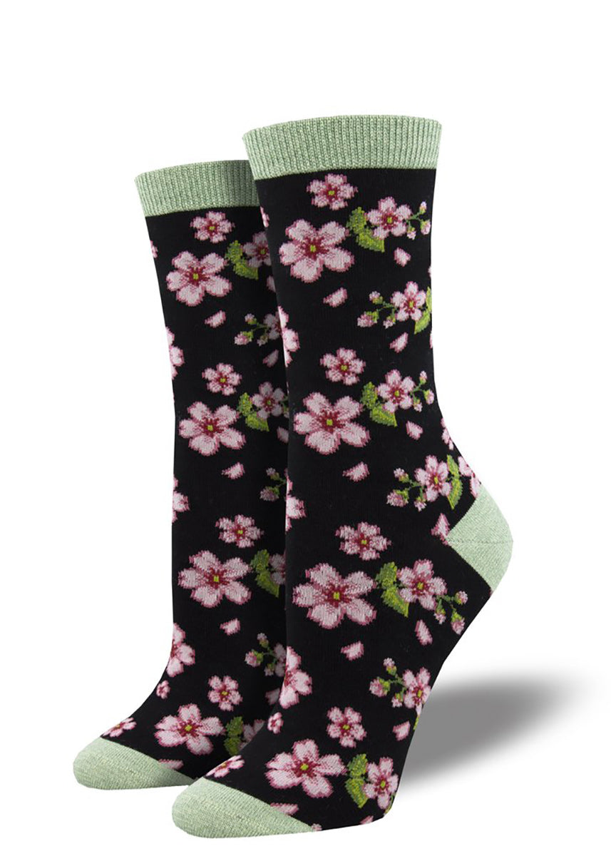 Bamboo crew socks for women feature sweet pink cherry blossom blooms on a black background.