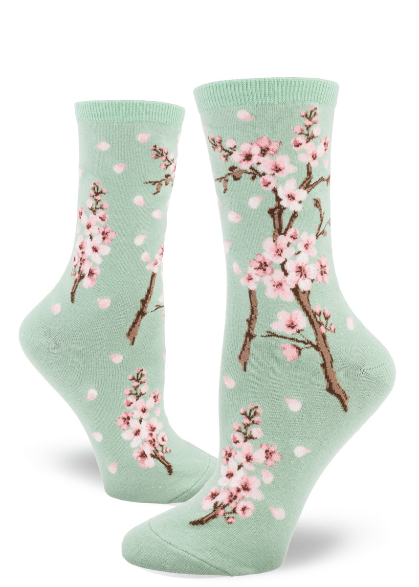 Spring socks for women feature pale pink cherry blossoms on a mint green background.